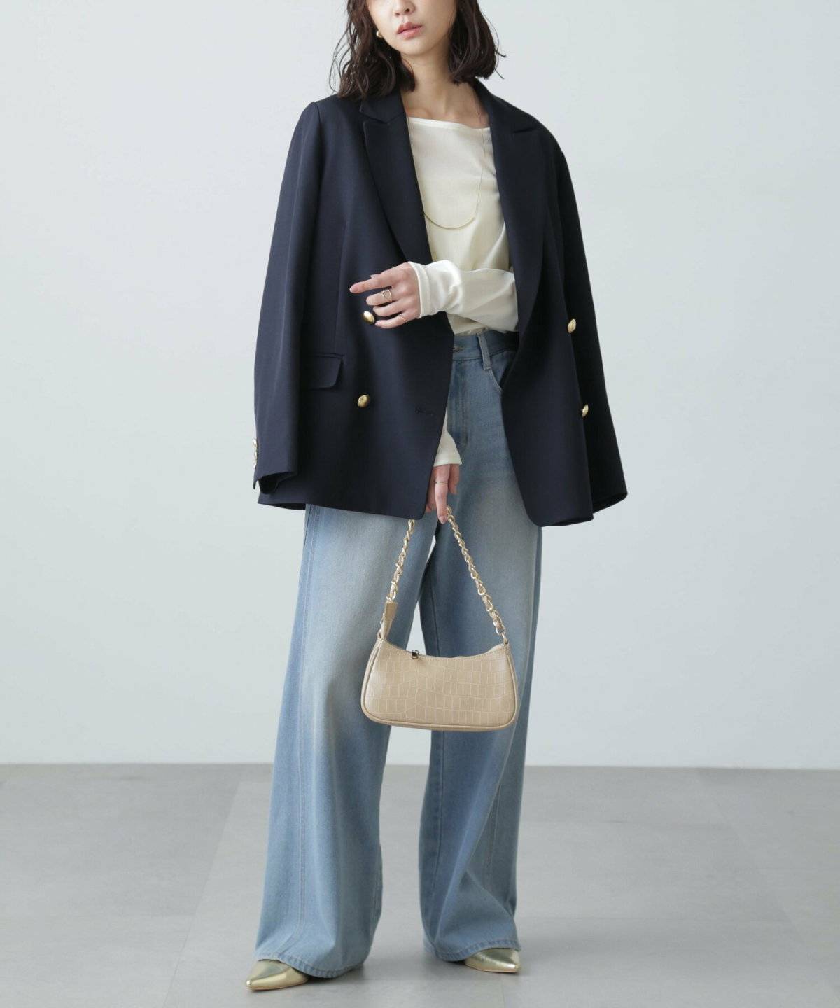 ネイビーのブレザーを肩掛けした女性