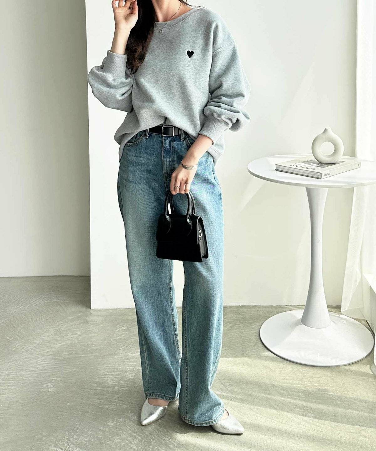 グレーのスウェットにデニムを合わせた女性
