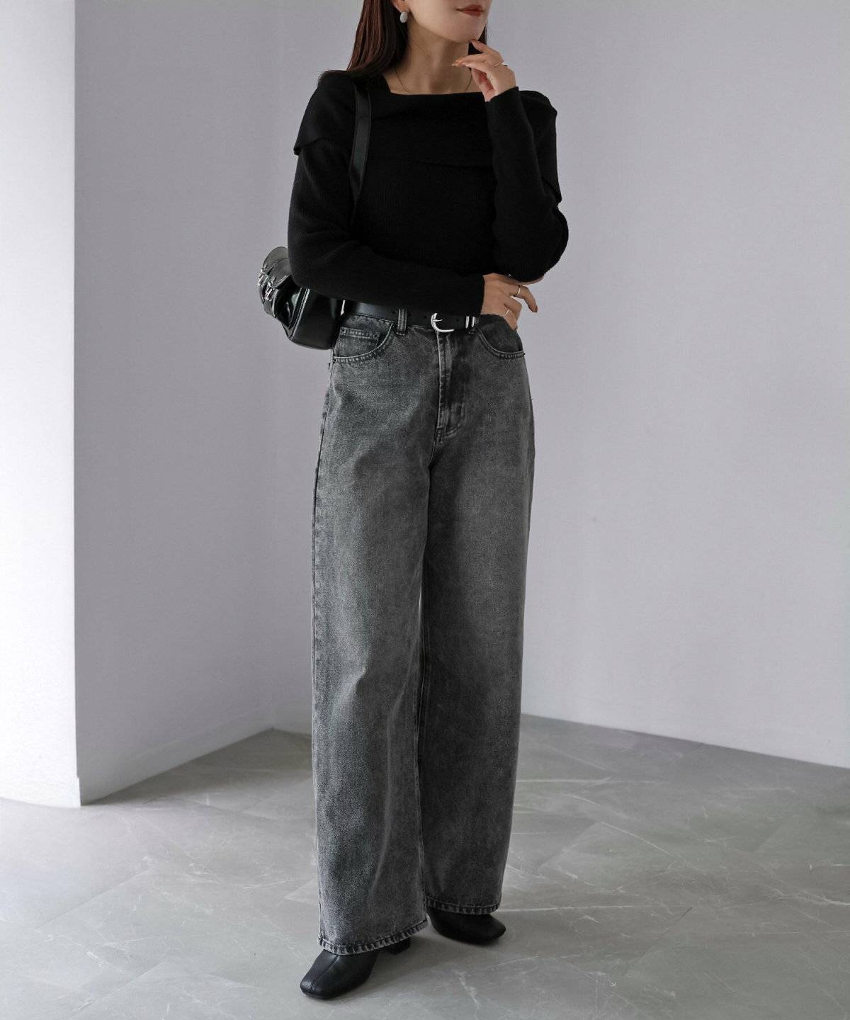 黒トップスにデニムを合わせた女性