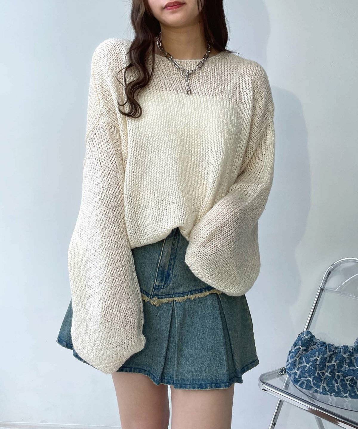 シアーニットにデニムスカートを合わせた女性