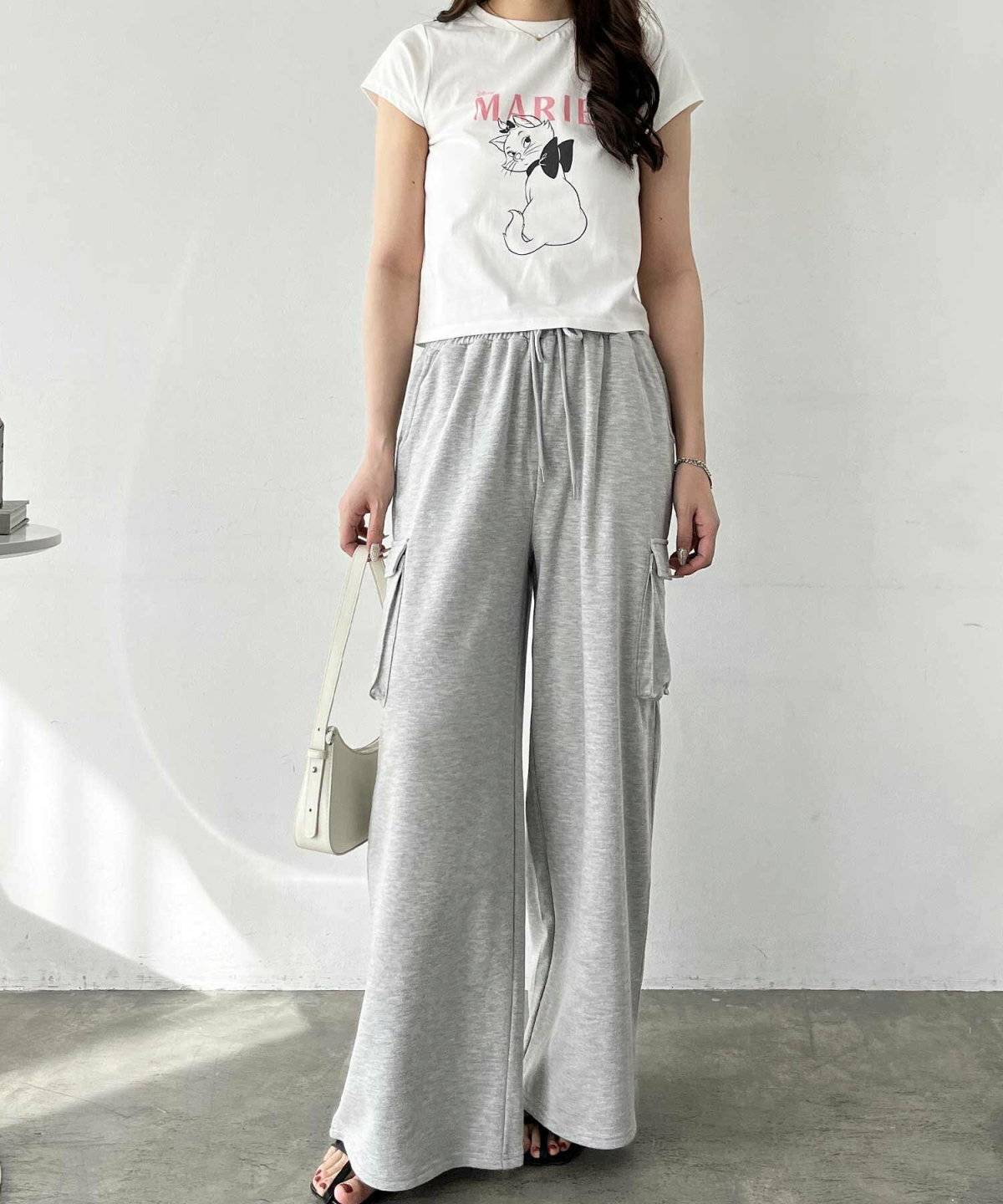 白トップスにグレーのパンツを合わせた女性
