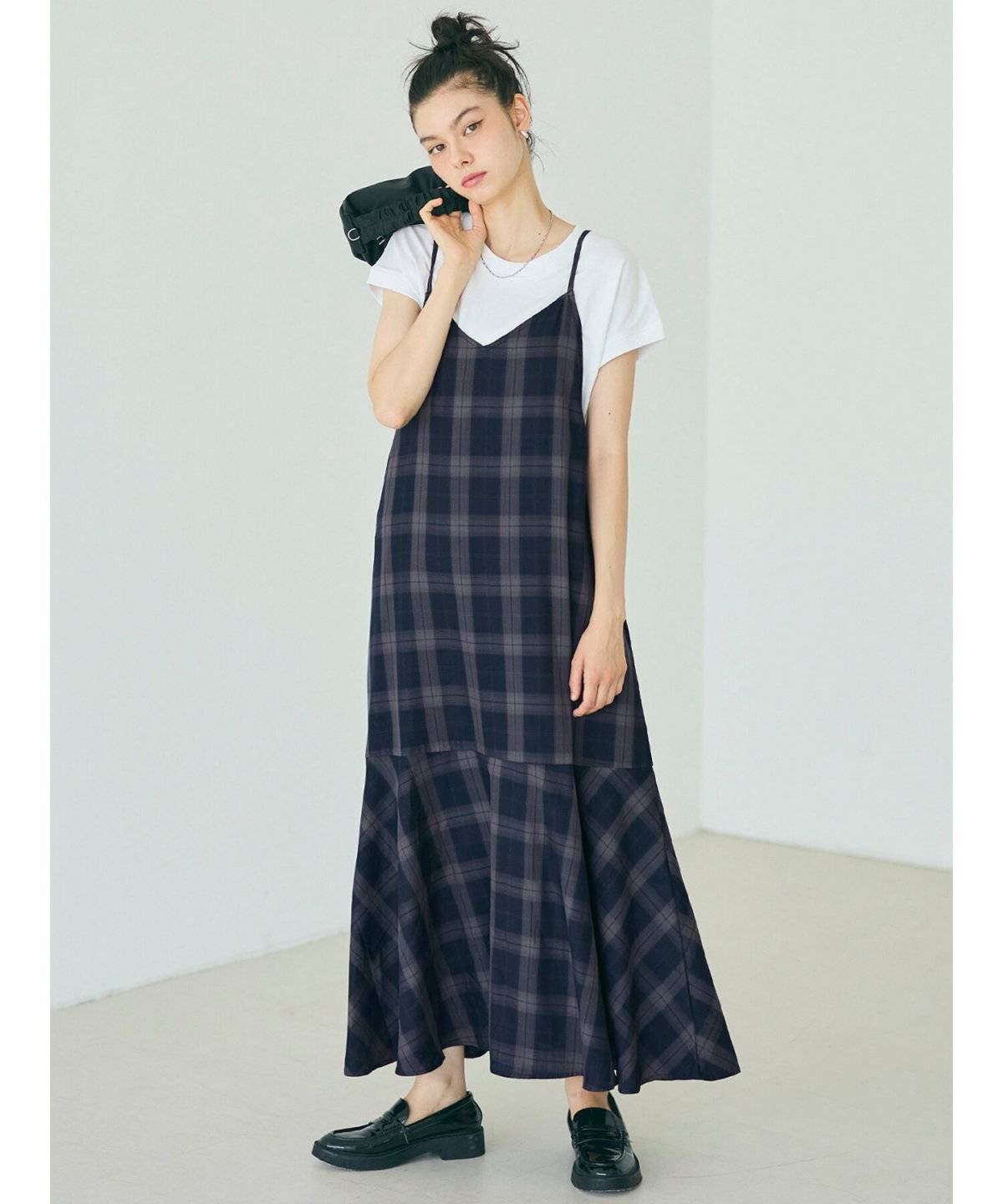 白トップスにチェック柄ワンピースを重ねた女性