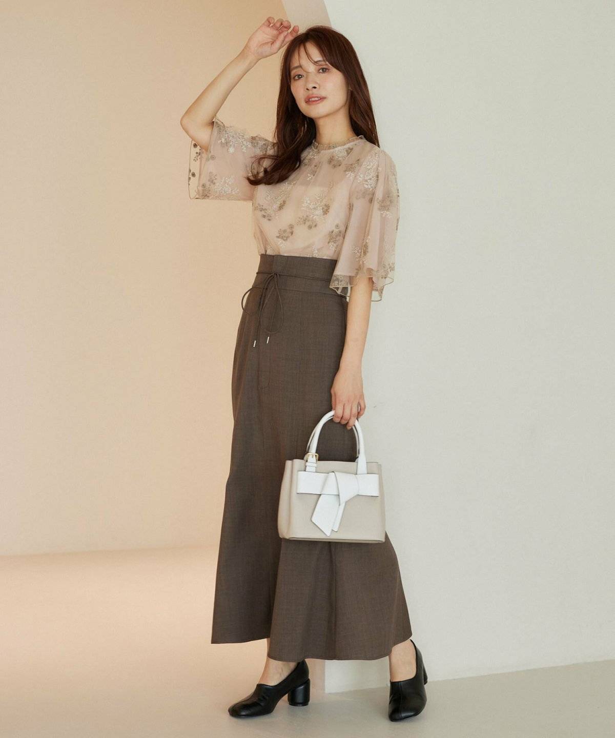 柄ブラウスにマーメイドスカートを合わせた女性