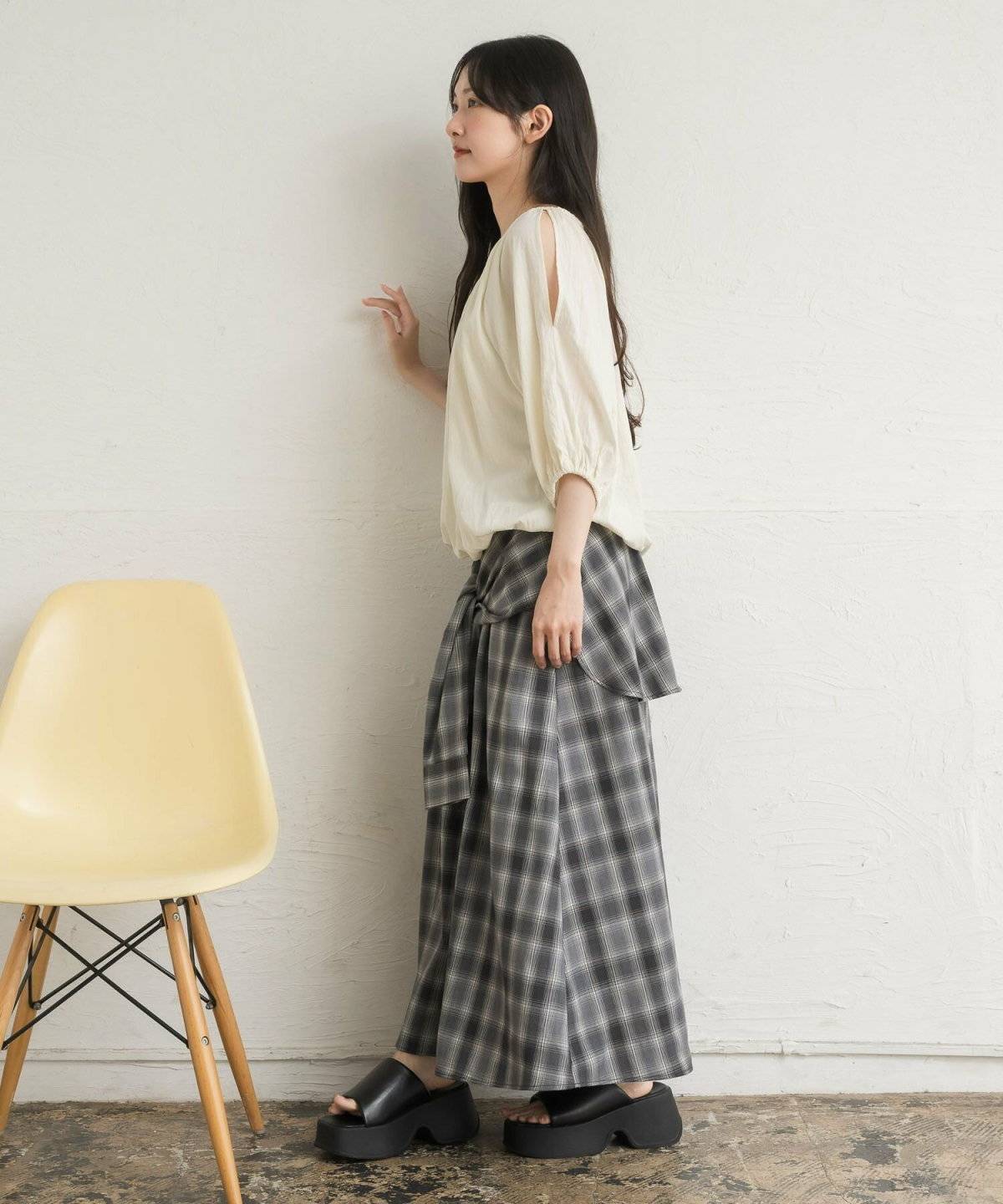 ベージュのブラウスにスカートを合わせた女性