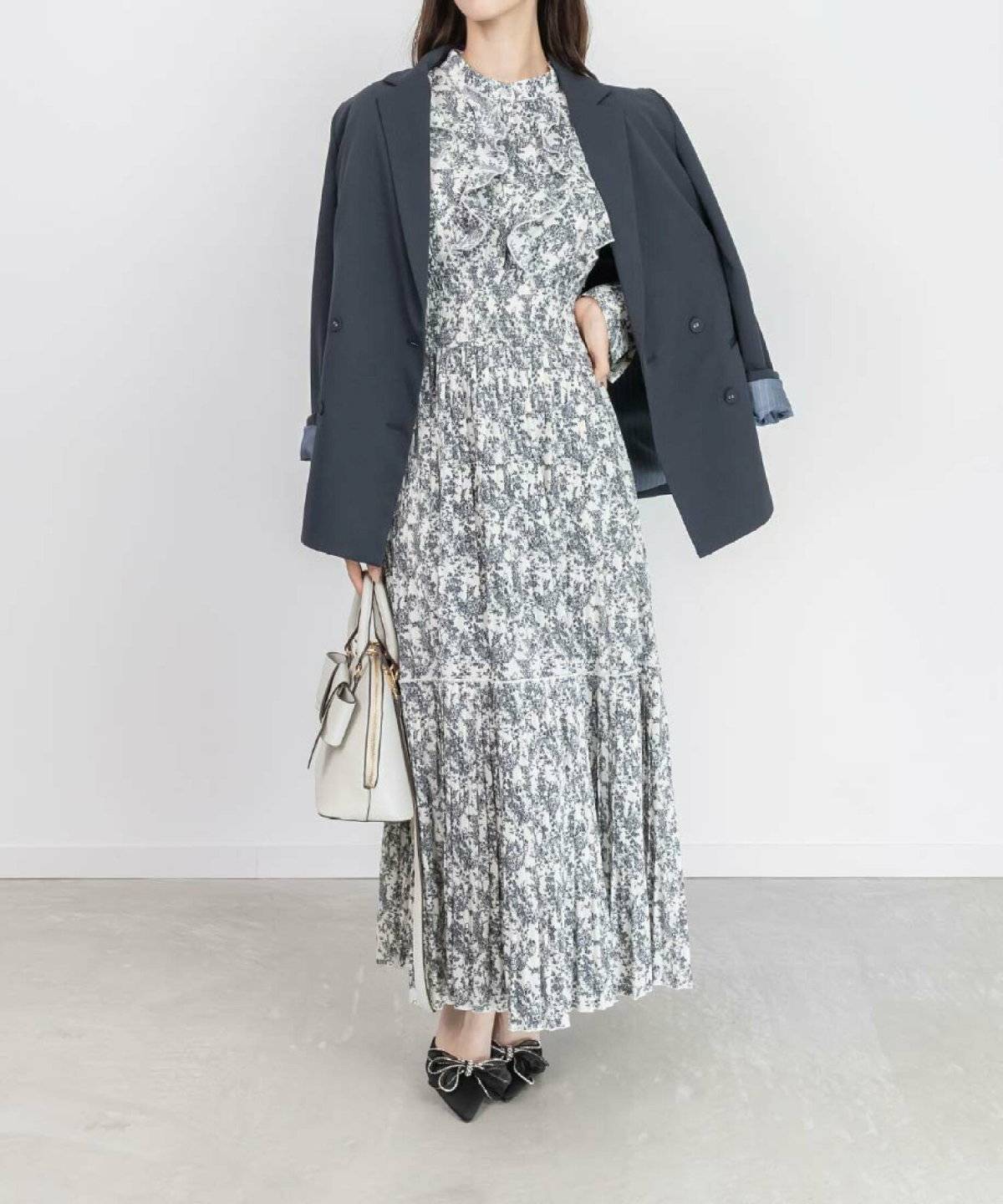 ワンピースにネイビージャケットを肩掛けした女性