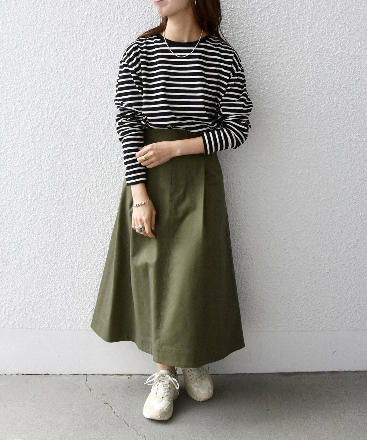 ボーダー柄のトップスにスカートを合わせた女性