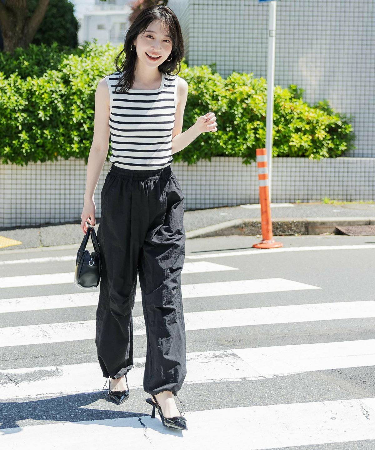 黒ニットにパープルのカーゴパンツを合わせた女性