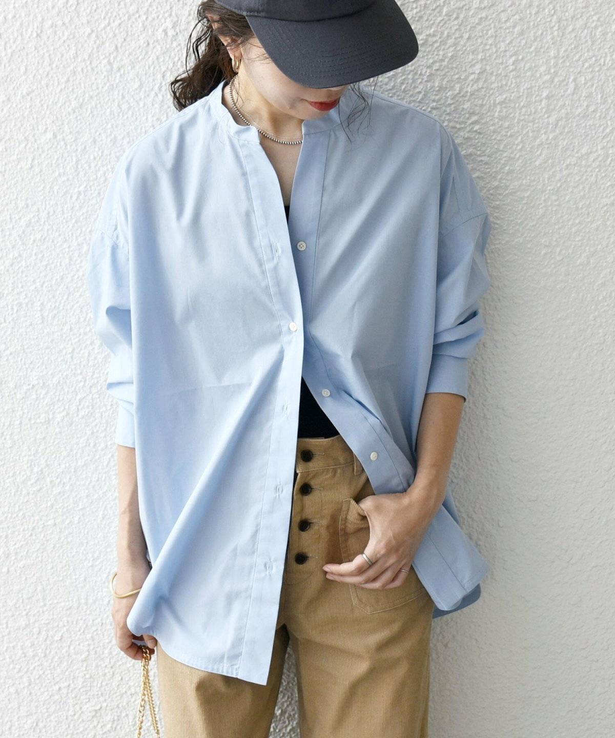 ブルーのシャツにベージュのシャツを合わせた女性