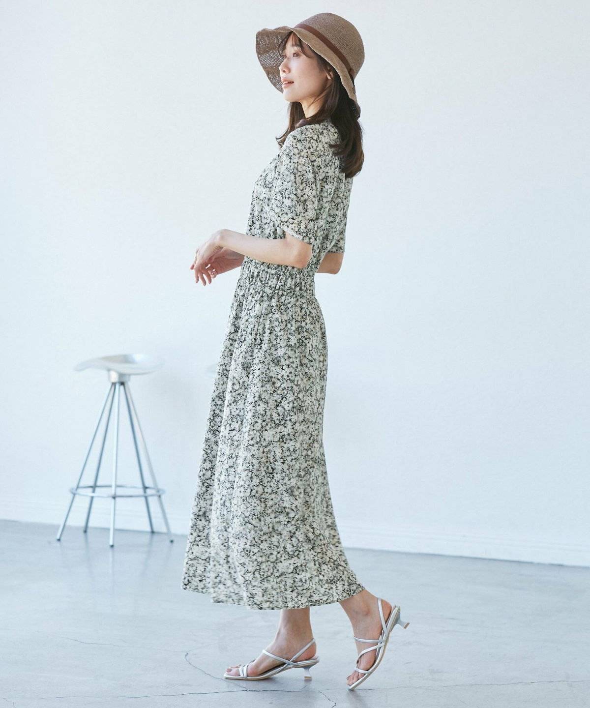 柄ワンピースに帽子をかぶった女性