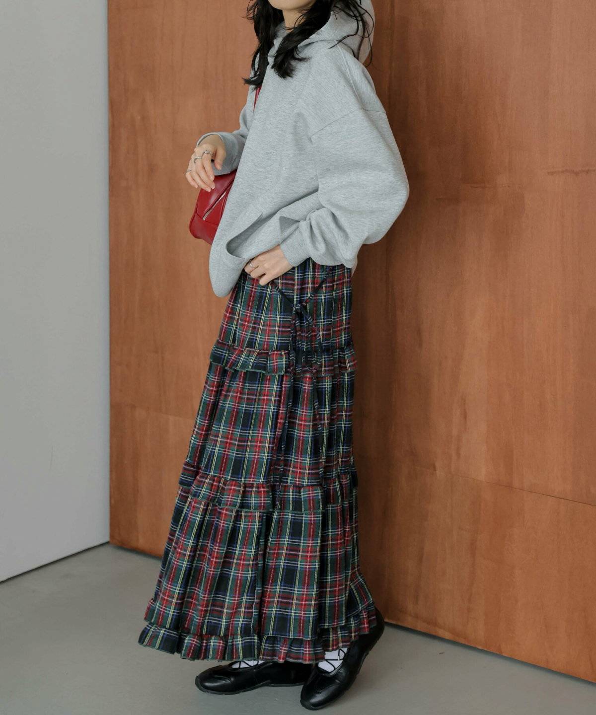 グレーのトップスにスカートを合わせた女性