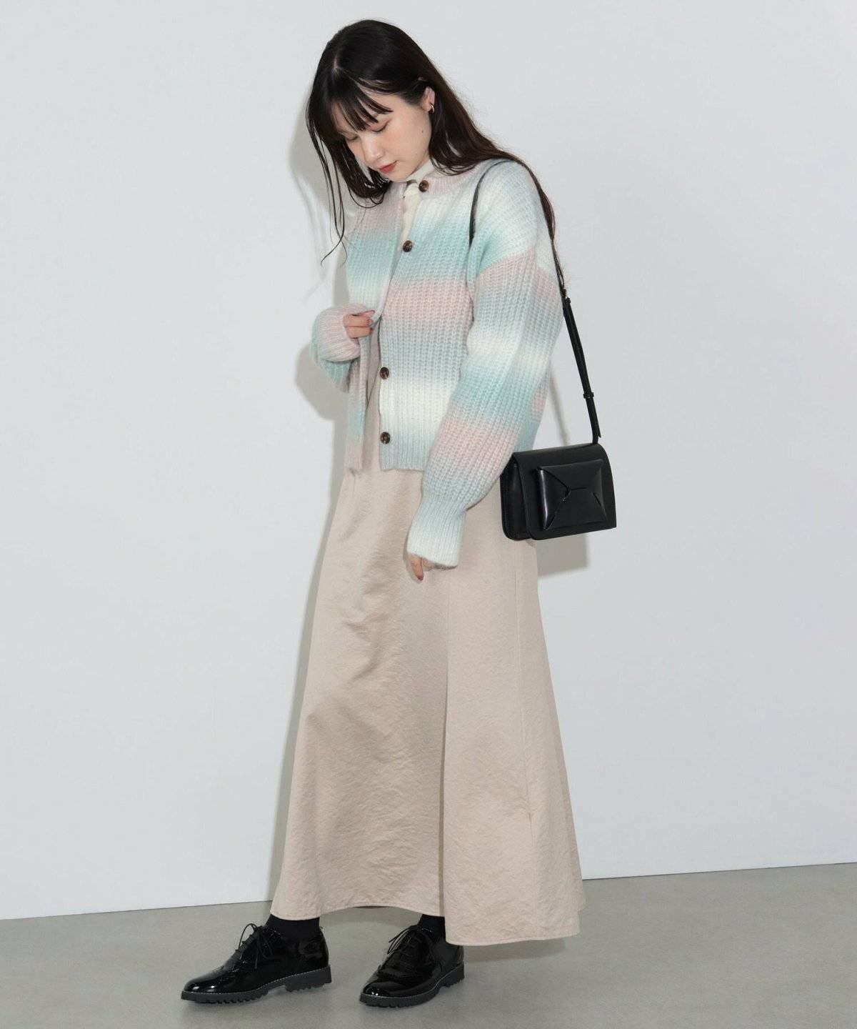 グラデーションカーディガンにスカートを合わせた女性