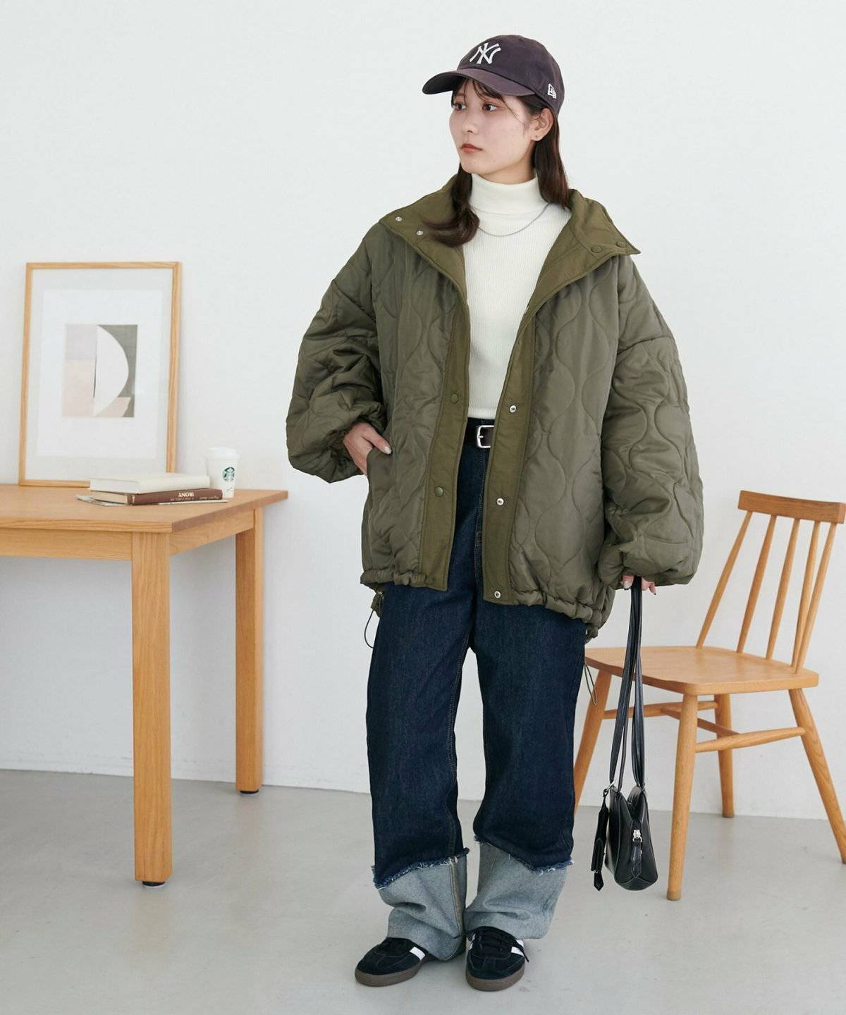 グリーンのブルゾンにデニムを合わせた女性