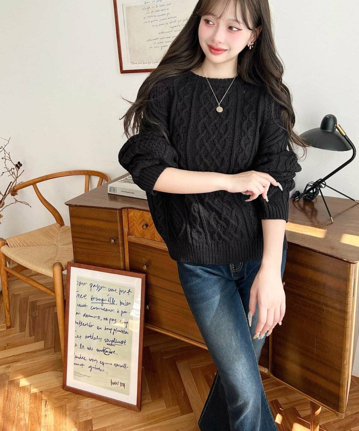 黒ニットにデニムを合わせた女性