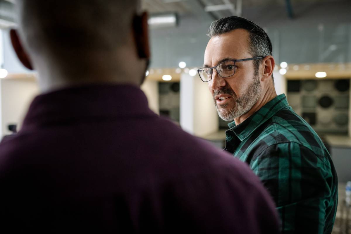 怒った様子で同僚と話す男性