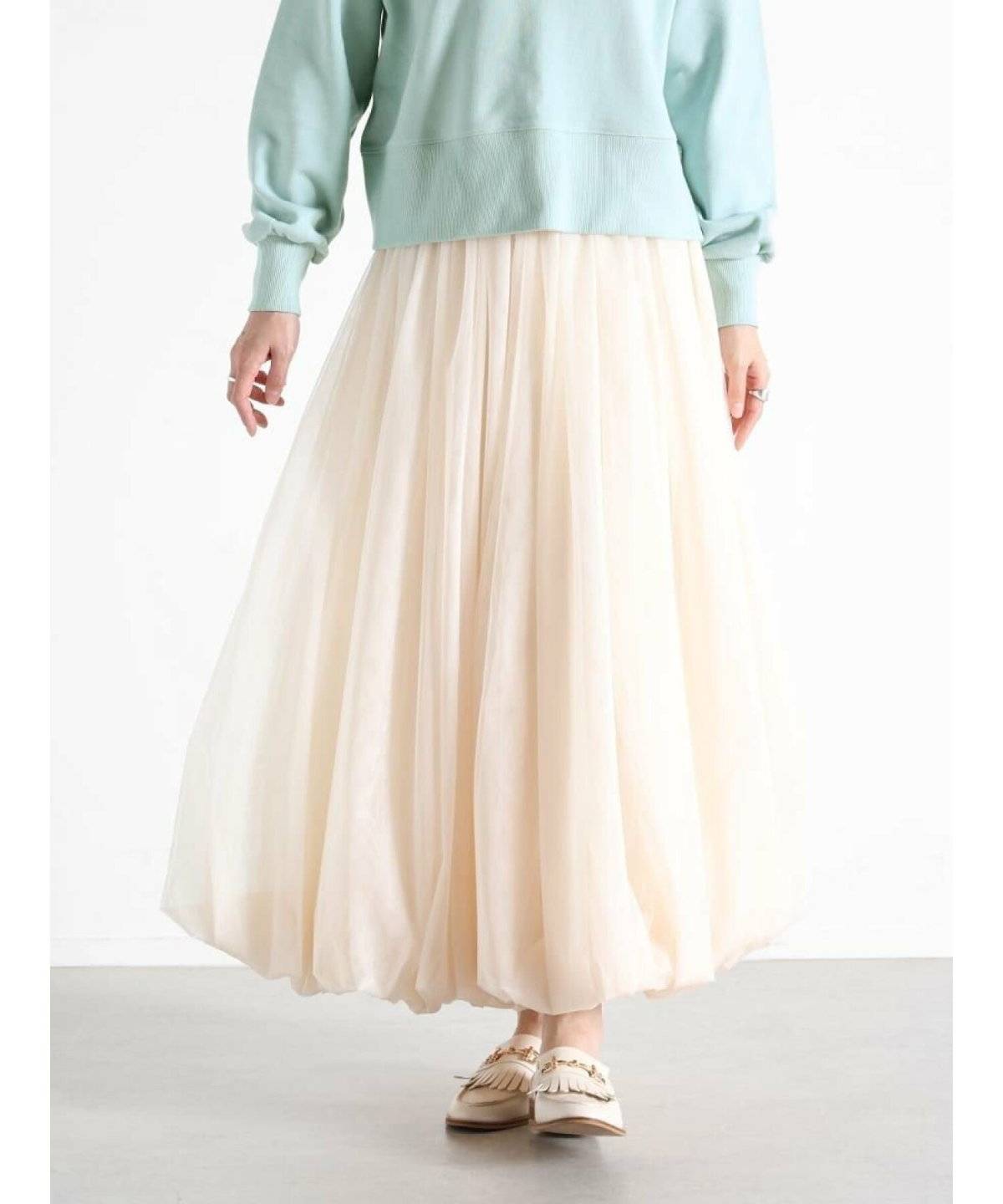 グリーンのスウェットにチュールスカートを合わせた女性