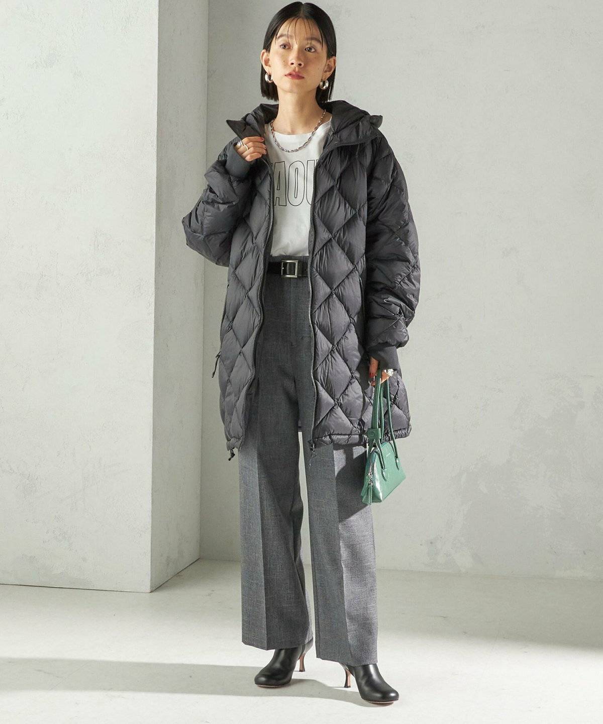 黒ダウンにグレーのパンツを合わせた女性