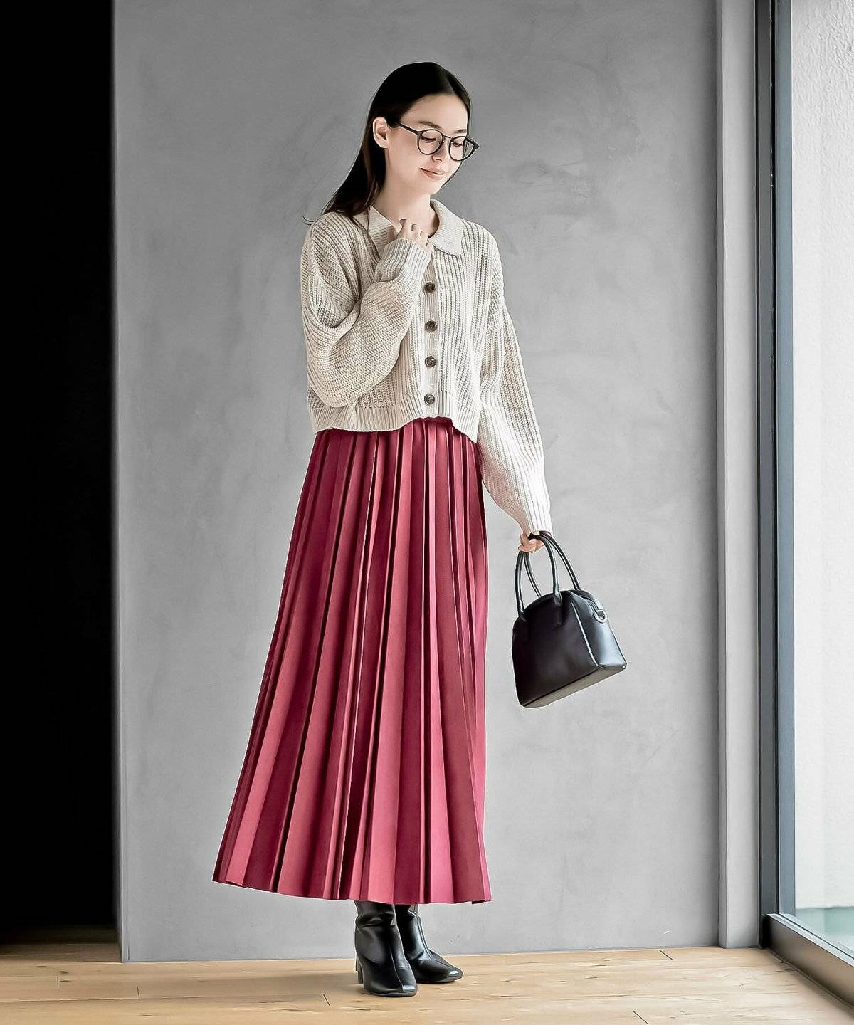 ベージュのカーディガンにスカートを合わせた女性