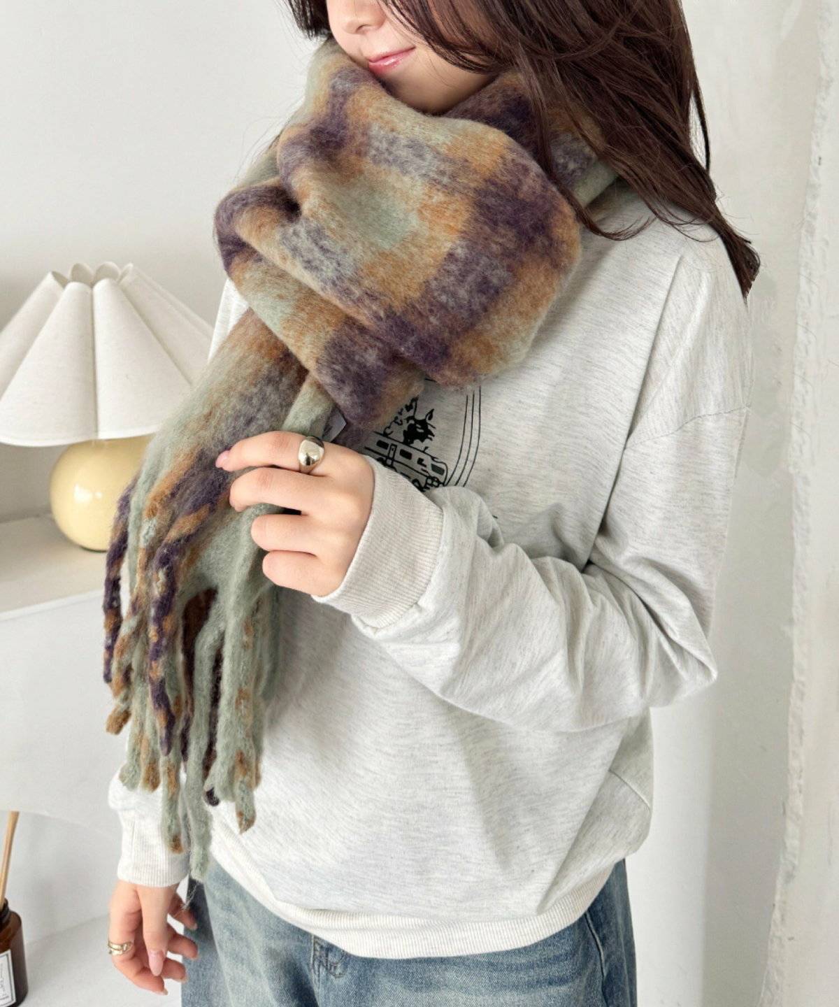 グレーのスウェットにデニムを合わせた女性