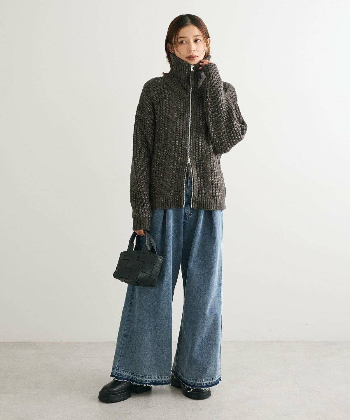 モノトーンコーデにグレーのカーディガンを羽織った女性