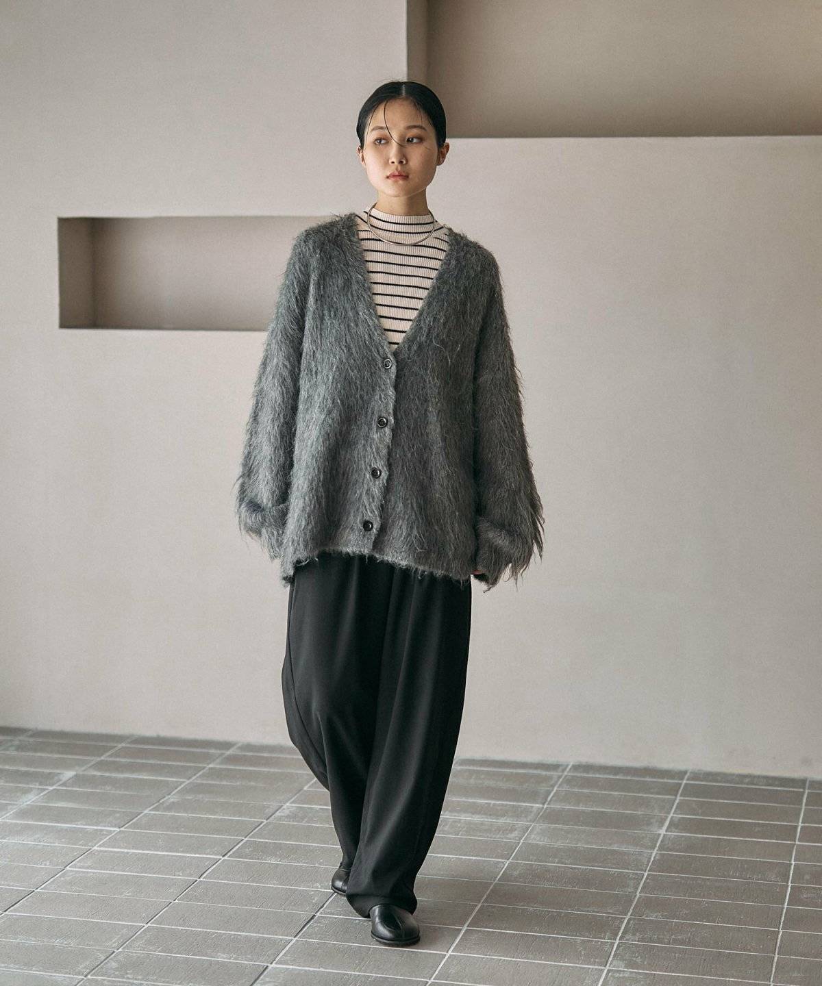 ボーダー柄トップスにデニムを合わせてグレーのカーディガンを羽織った女性