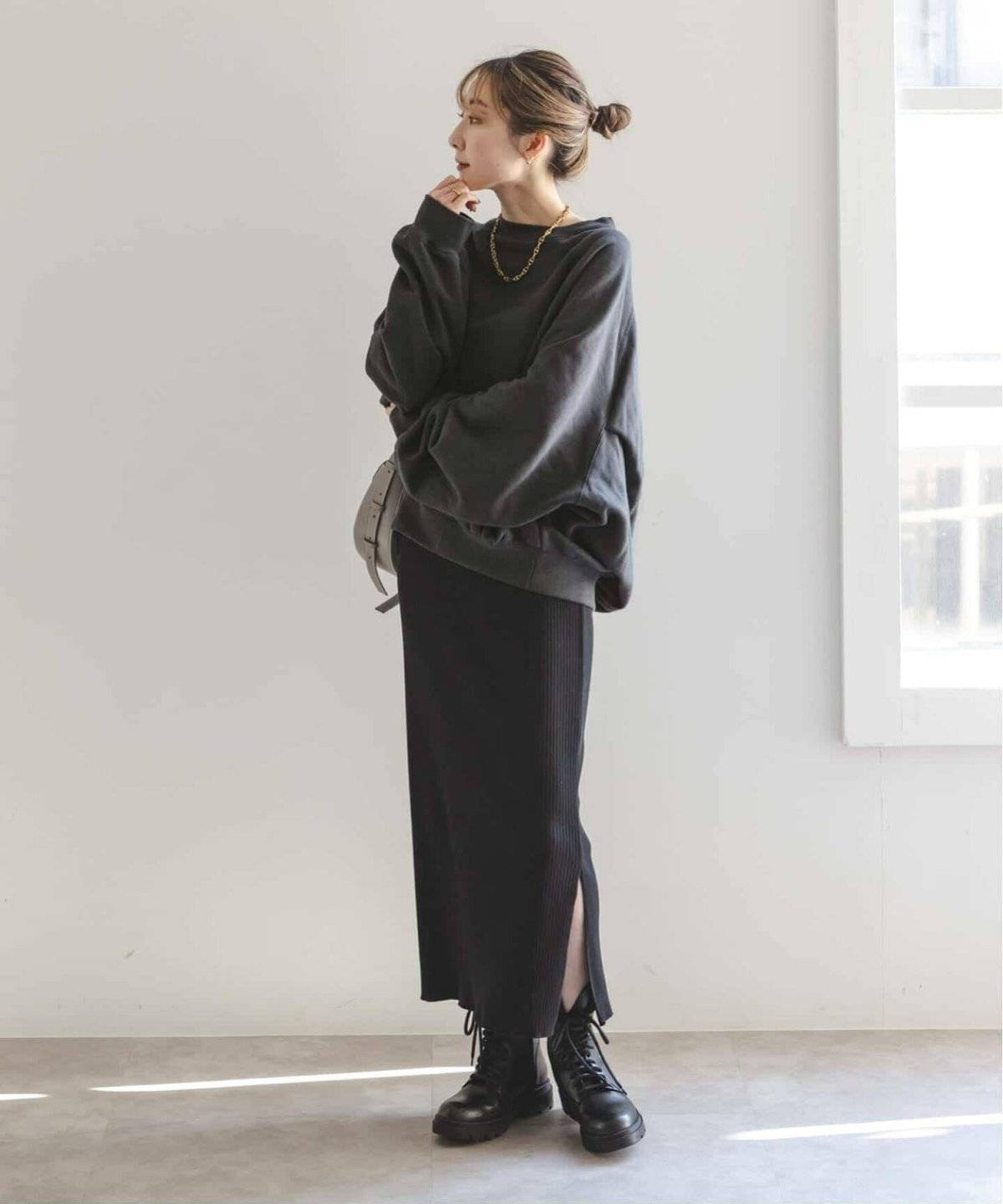 グレーのスウェットに黒スカートを合わせた女性