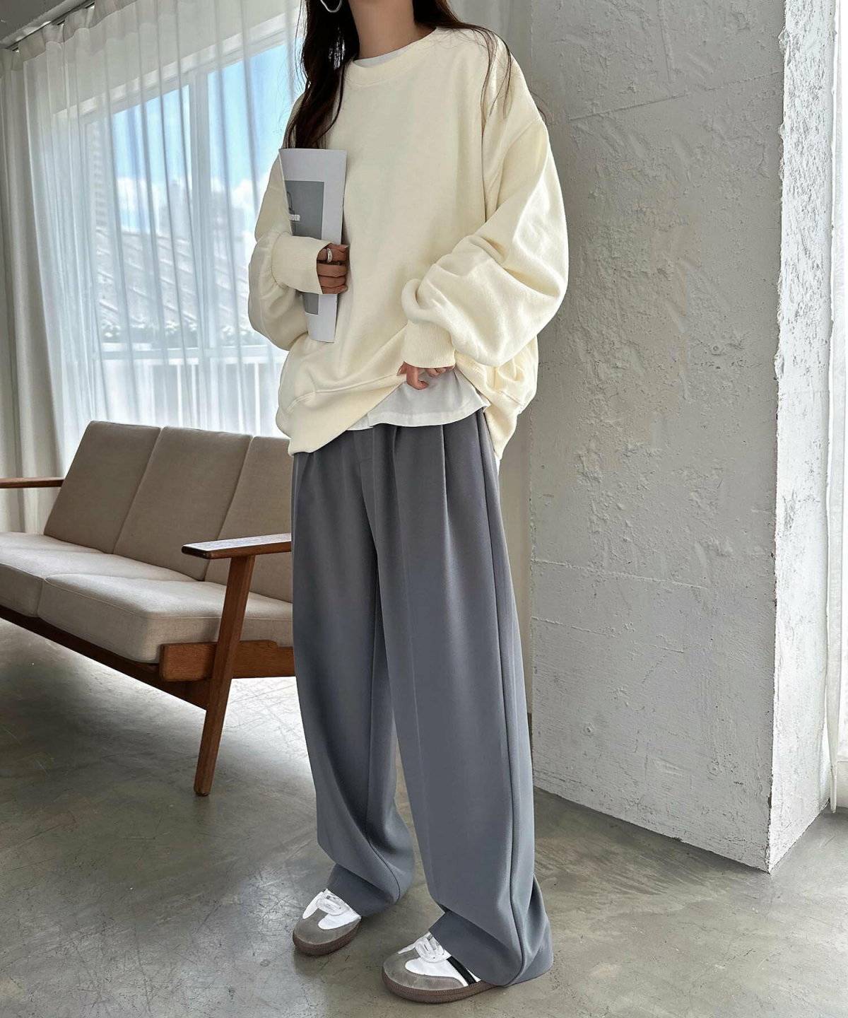 白のスウェットにグレーのパンツを合わせた女性