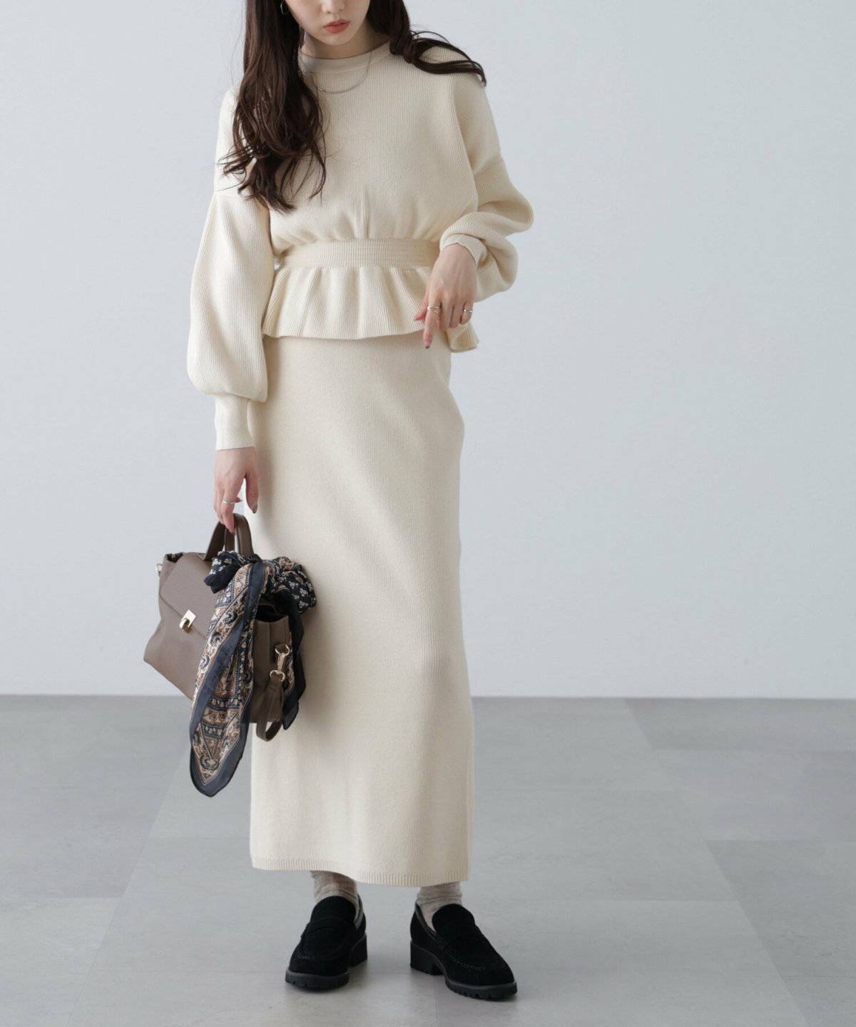 白のニットセットアップを着た女性