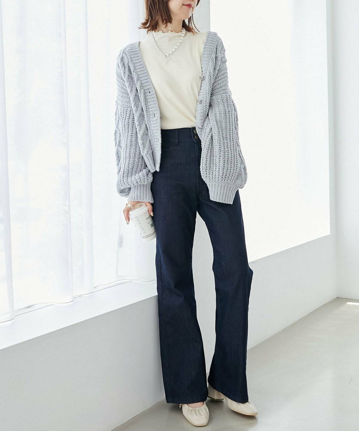 ブルーのカーディガンを羽織ってパンツを合わせた女性