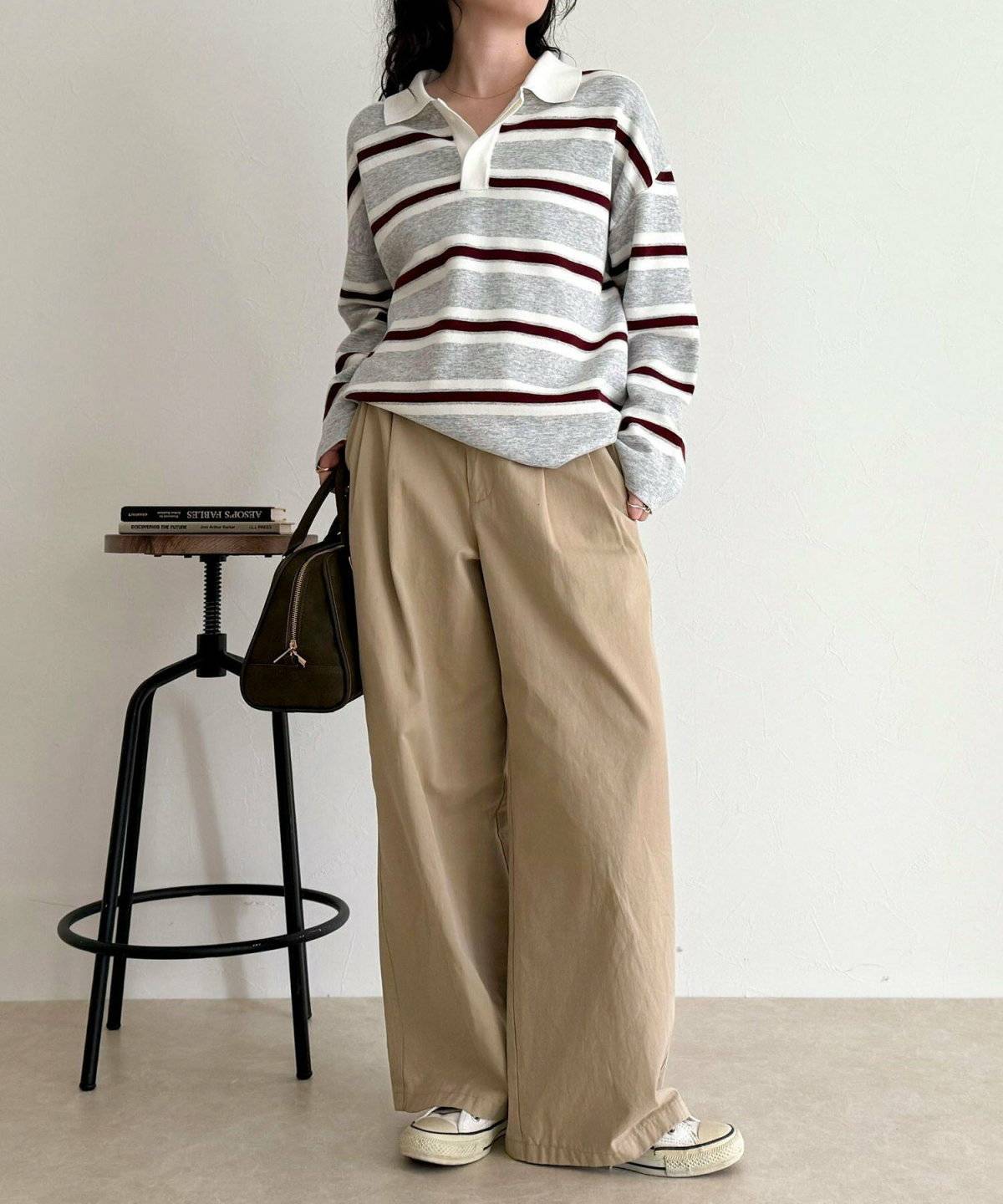 ボーダー柄ニットにベージュのパンツを合わせた女性