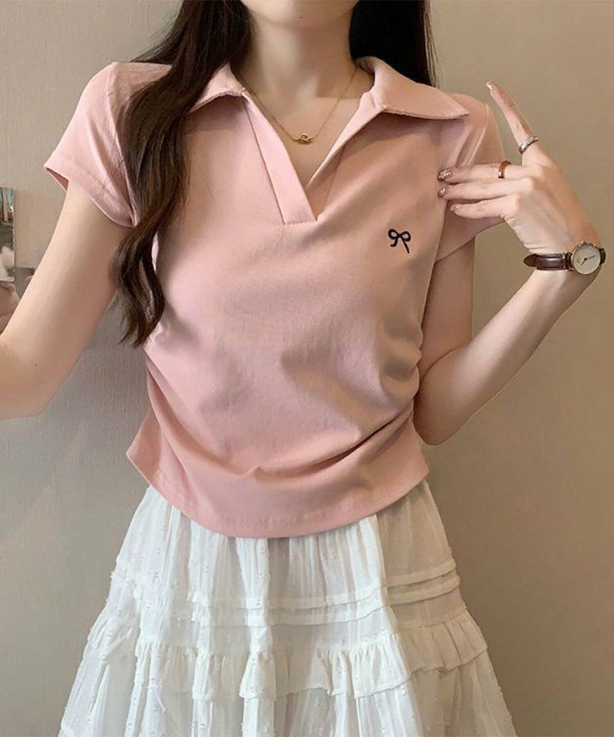 ピンクのポロシャツにスカートを合わせた女性