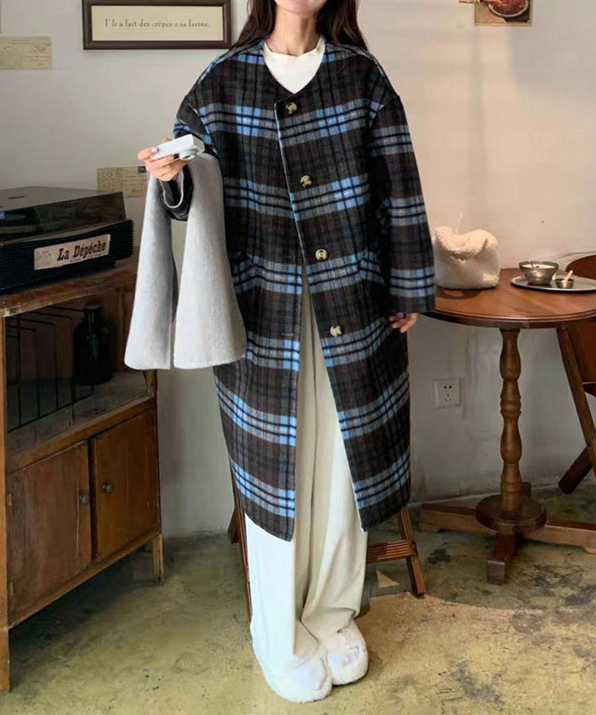 チェック柄コートにベージュのパンツを合わせた女性