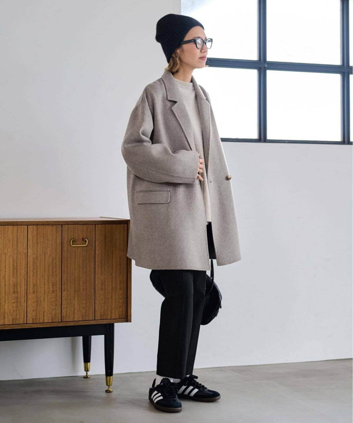 グレーのコートに黒パンツを合わせた女性