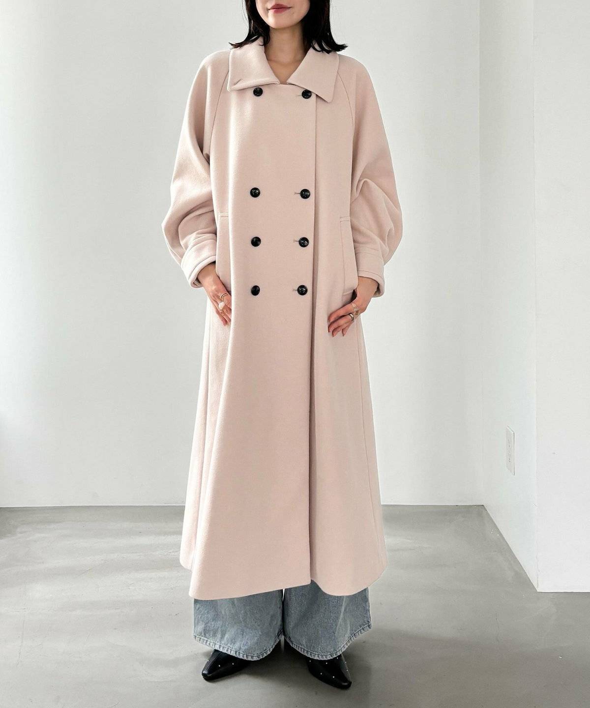 ピンクのロングコートを羽織った女性