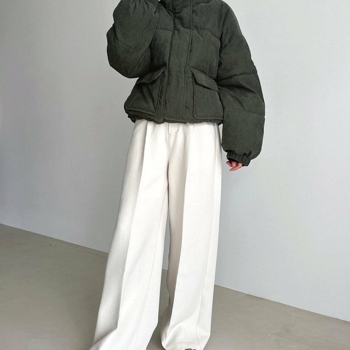 グレーのダウンにパンツを合わせた女性