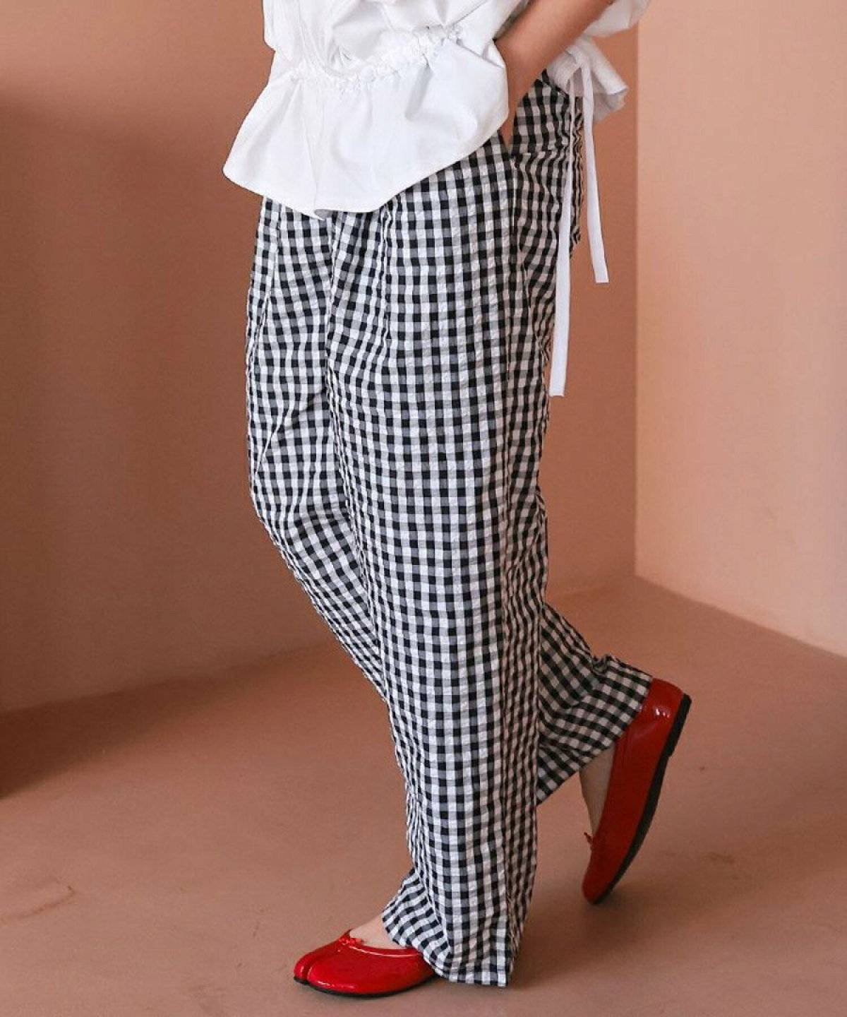 白シャツにギンガムチェック柄パンツを合わせた女性
