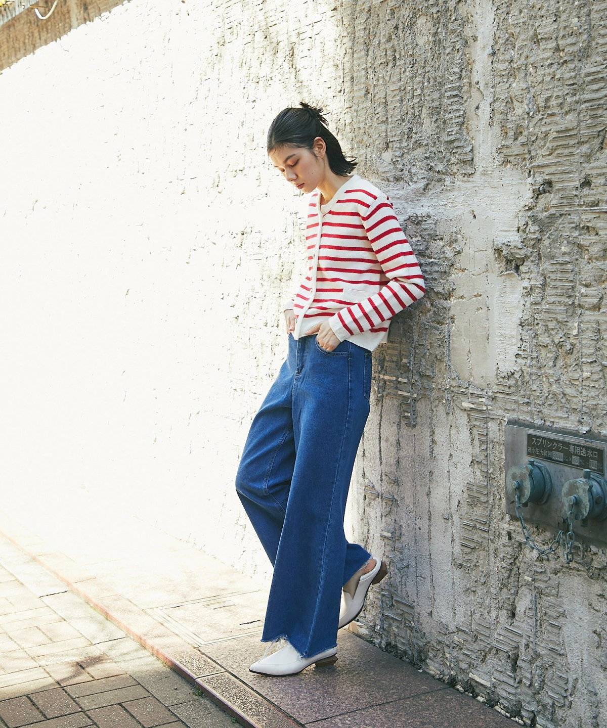 ボーダー柄カーディガンにデニムを合わせた女性