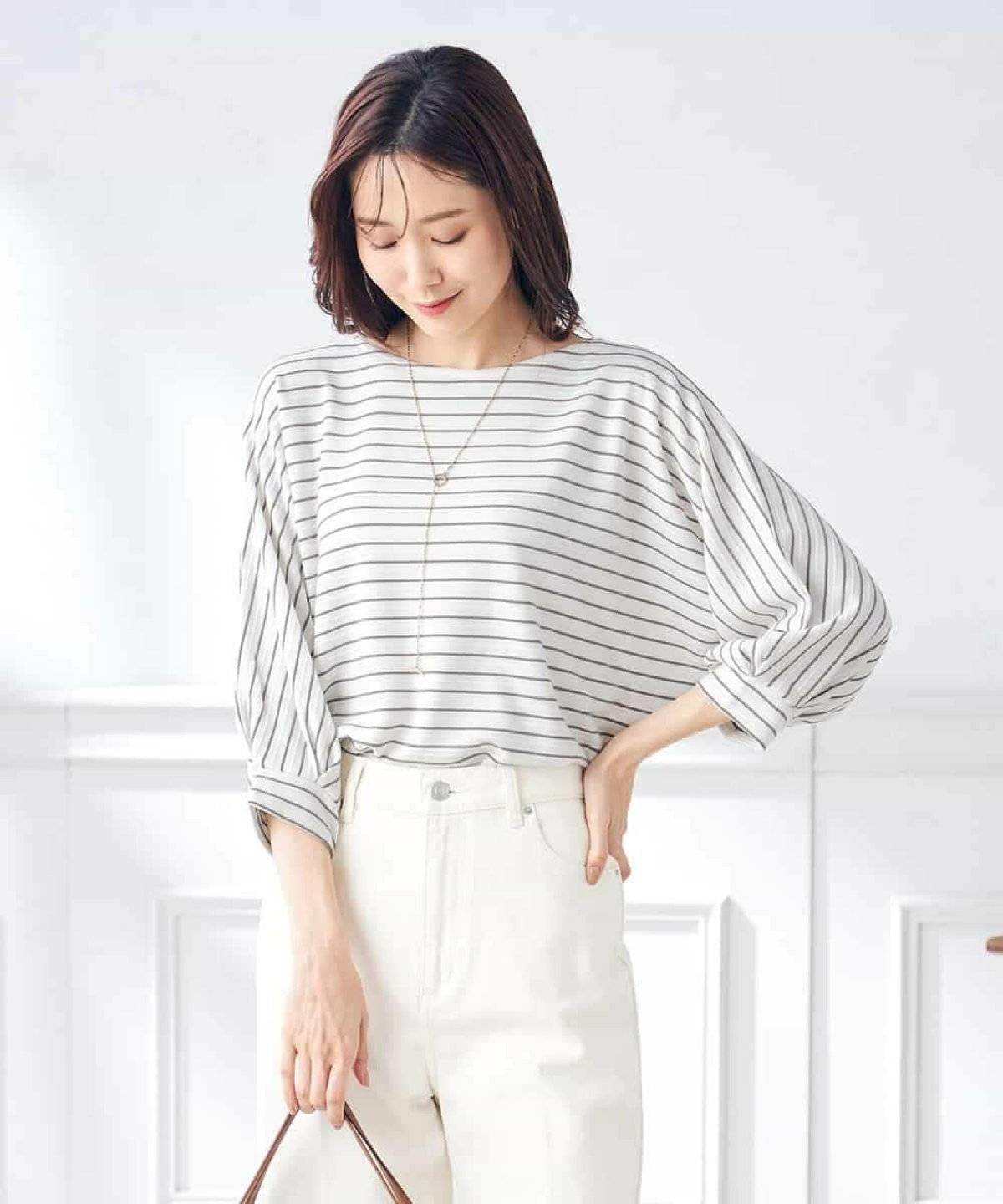 ボーダー柄トップスに白デニムを合わせた女性