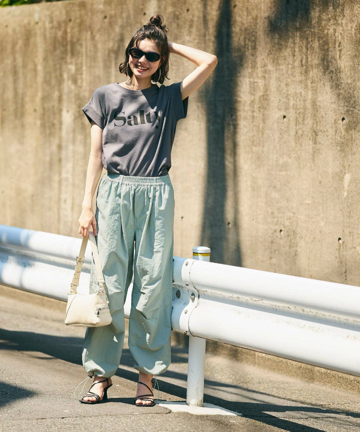 Tシャツにグリーンのパンツを合わせた女性