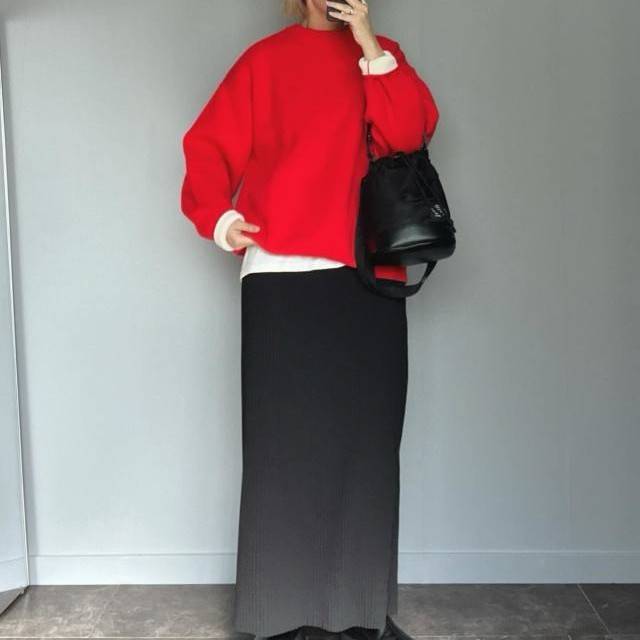 赤ニットに黒スカートを合わせた女性
