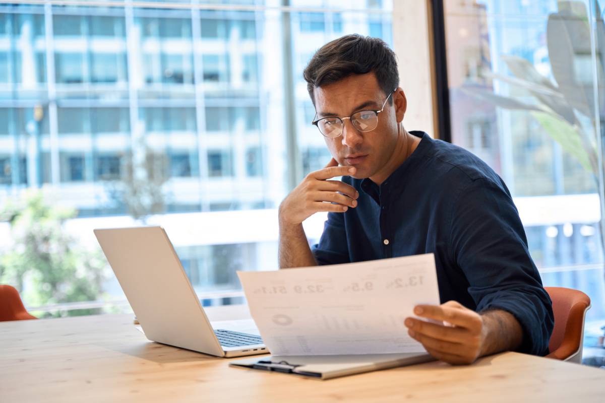 書類を見ながら考える男性