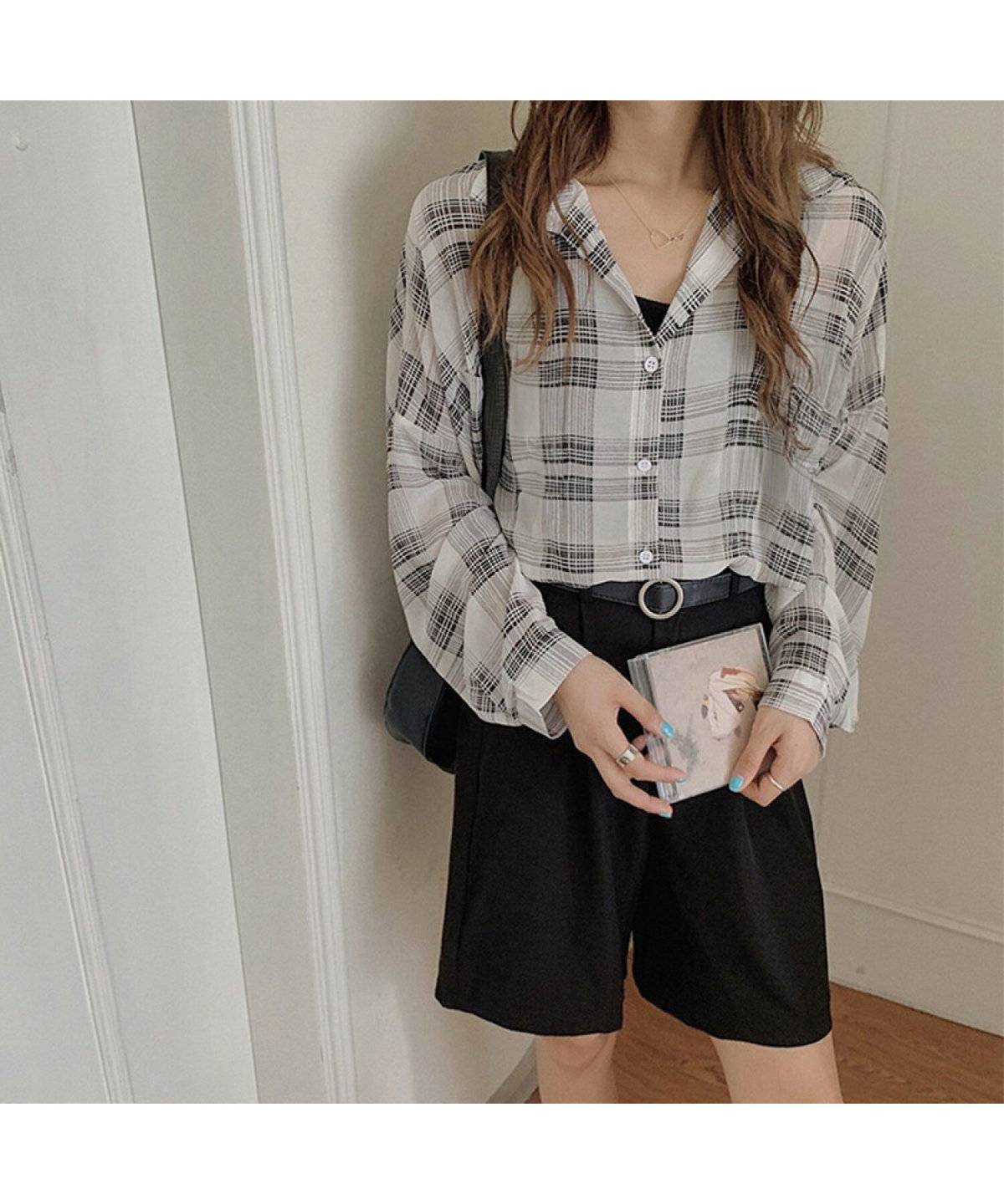 ブラックコーデにチェック柄シャツを羽織った女性