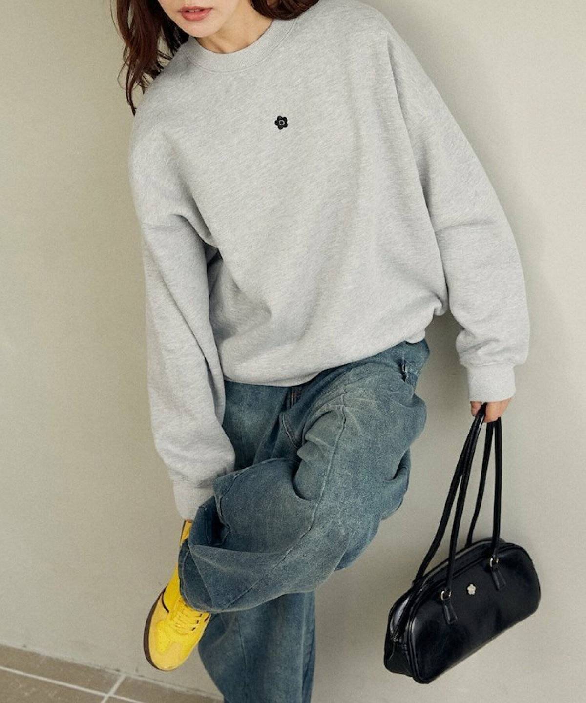 グレーのスウェットにデニムを合わせた女性