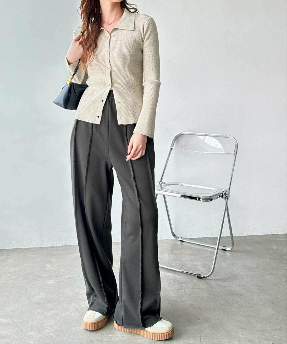 カーディガンにグレーのパンツを合わせた女性