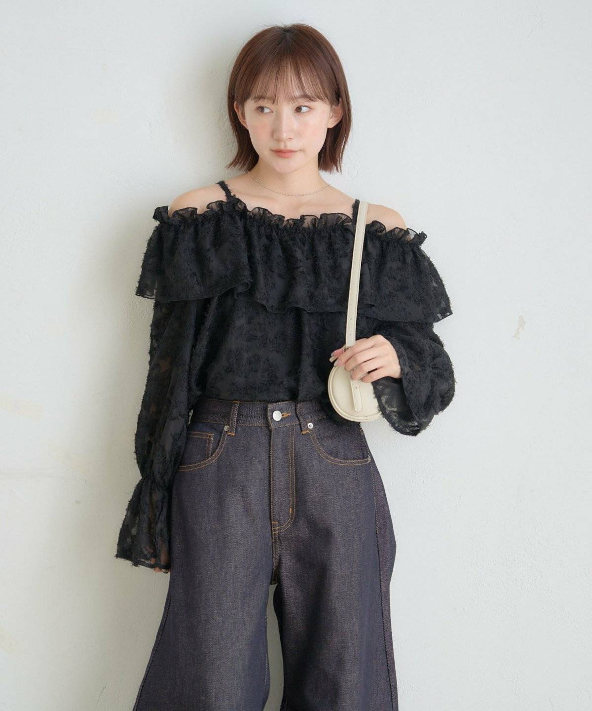 黒トップスにパンツを合わせた女性