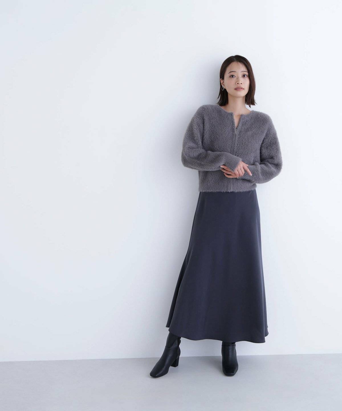 モノトーンコーデにグレーのカーディガンを合わせた女性