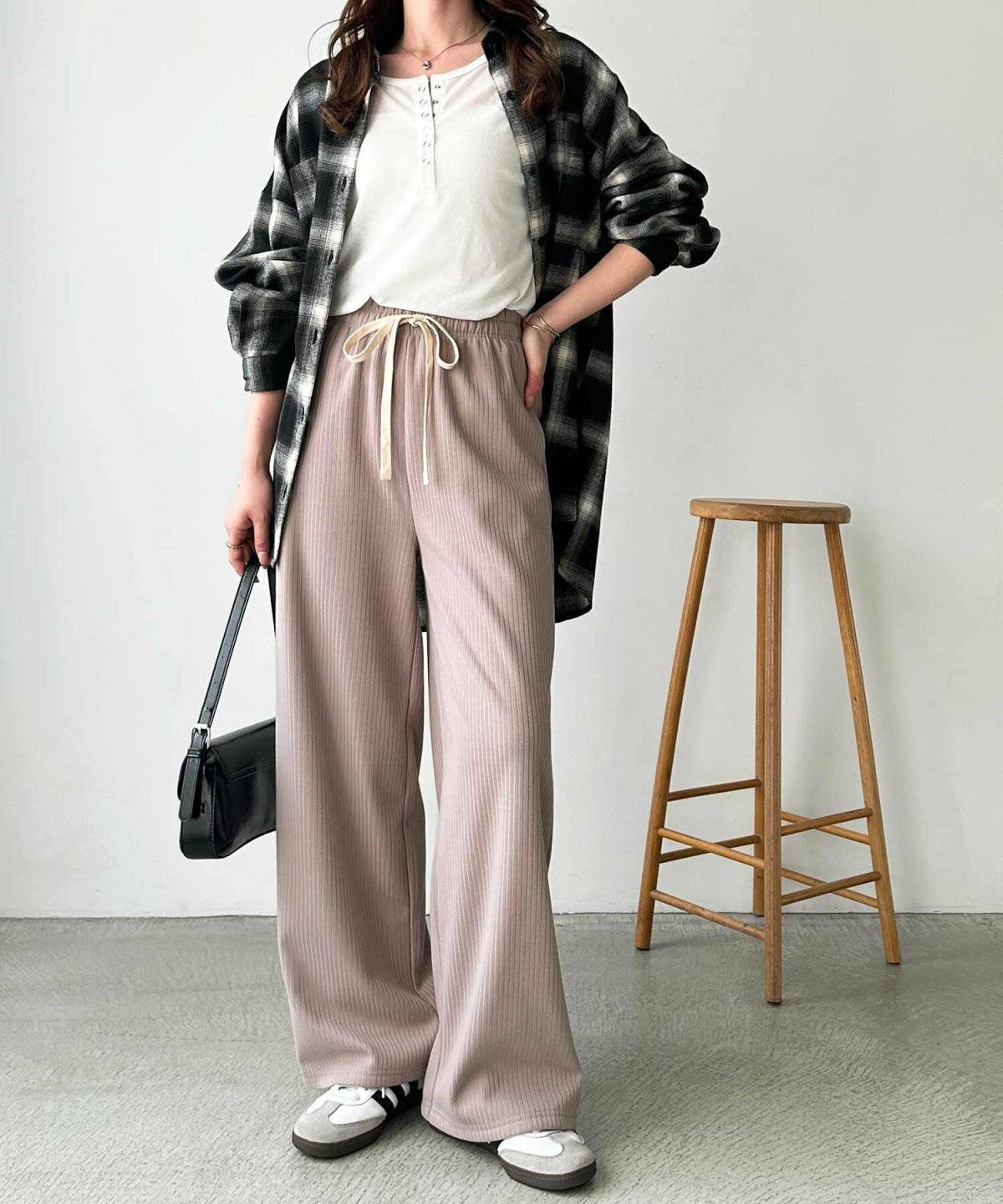 白トップスにベージュパンツを合わせた女性