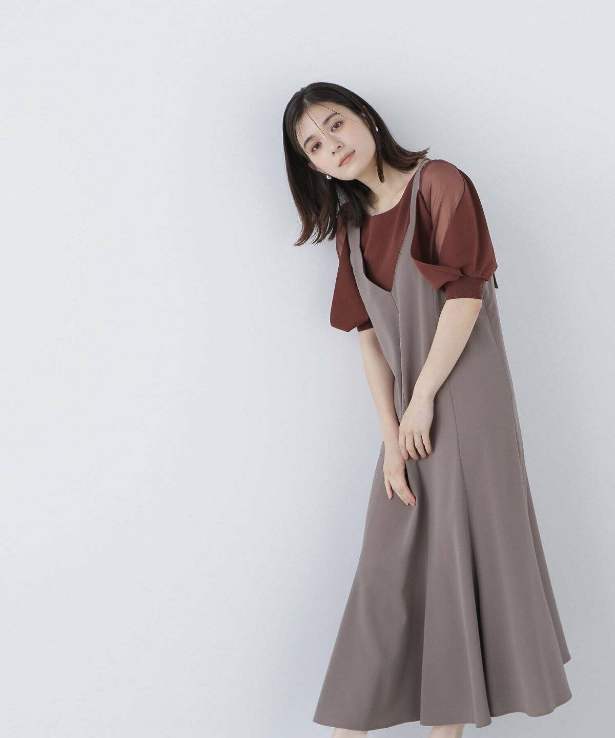 ブラウンのジャンパースカートを合わせた女性
