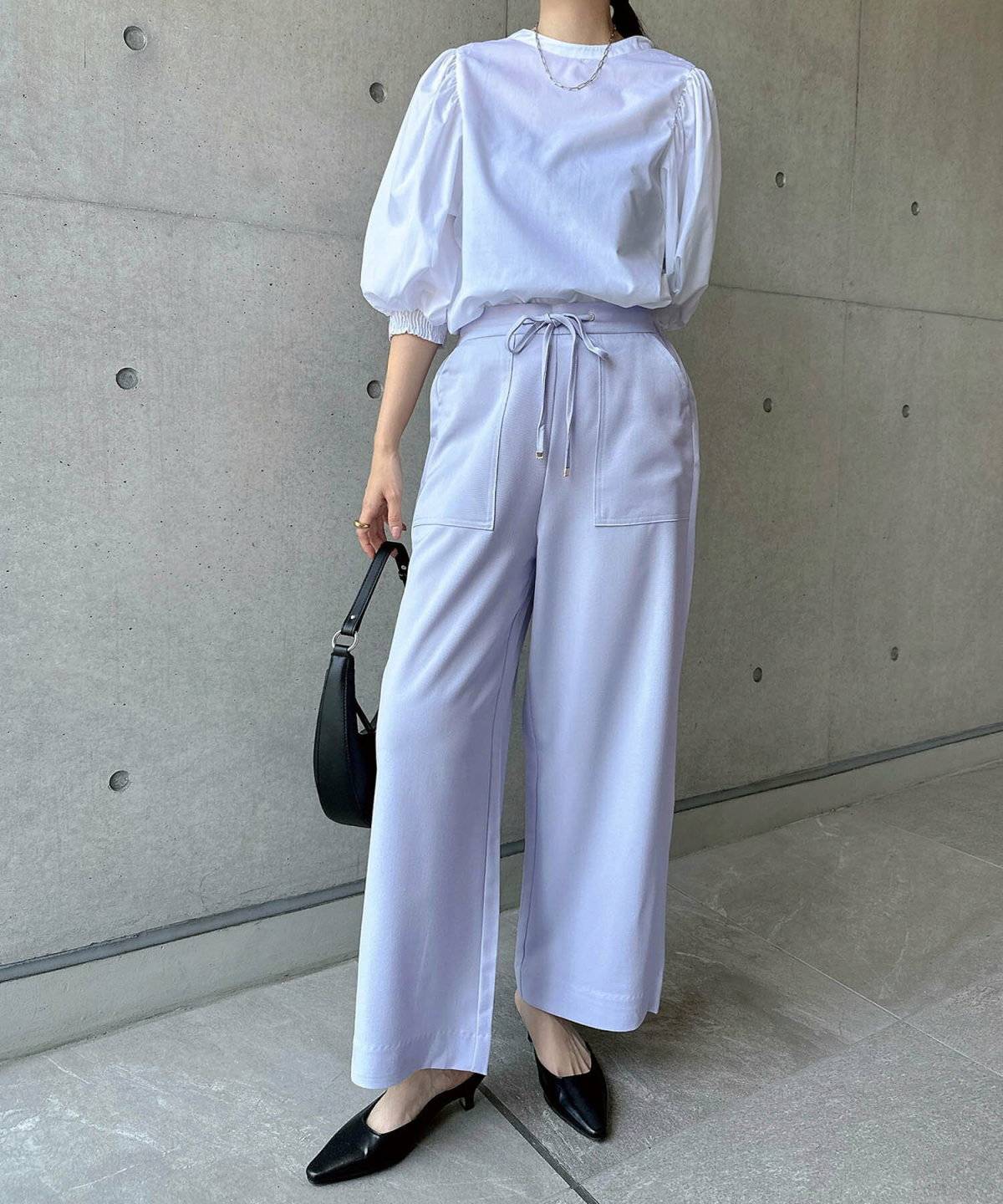 ラベンダーワイドパンツ✕白ブラウスの女性