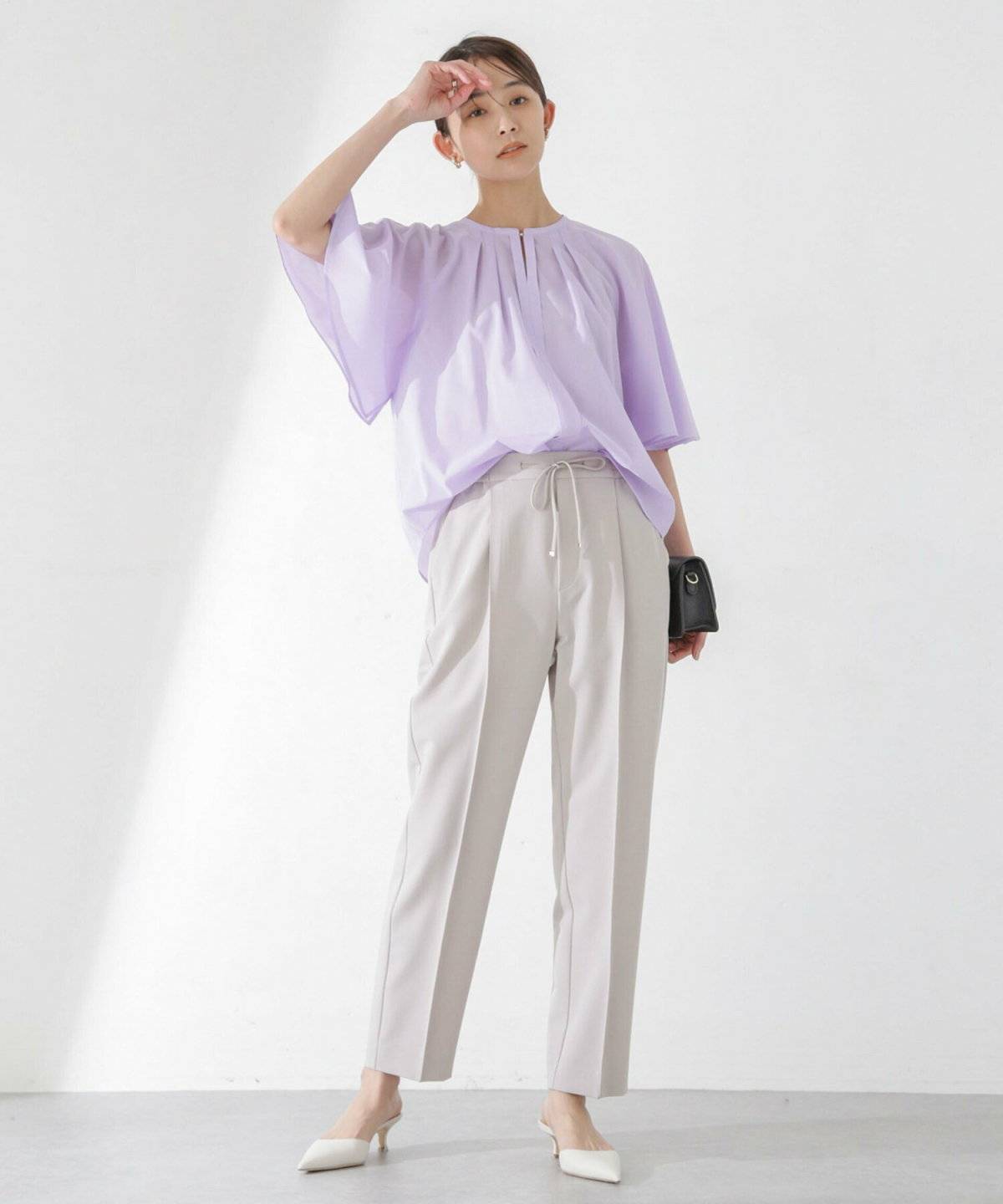 ラベンダーブラウス✕白パンツの女性