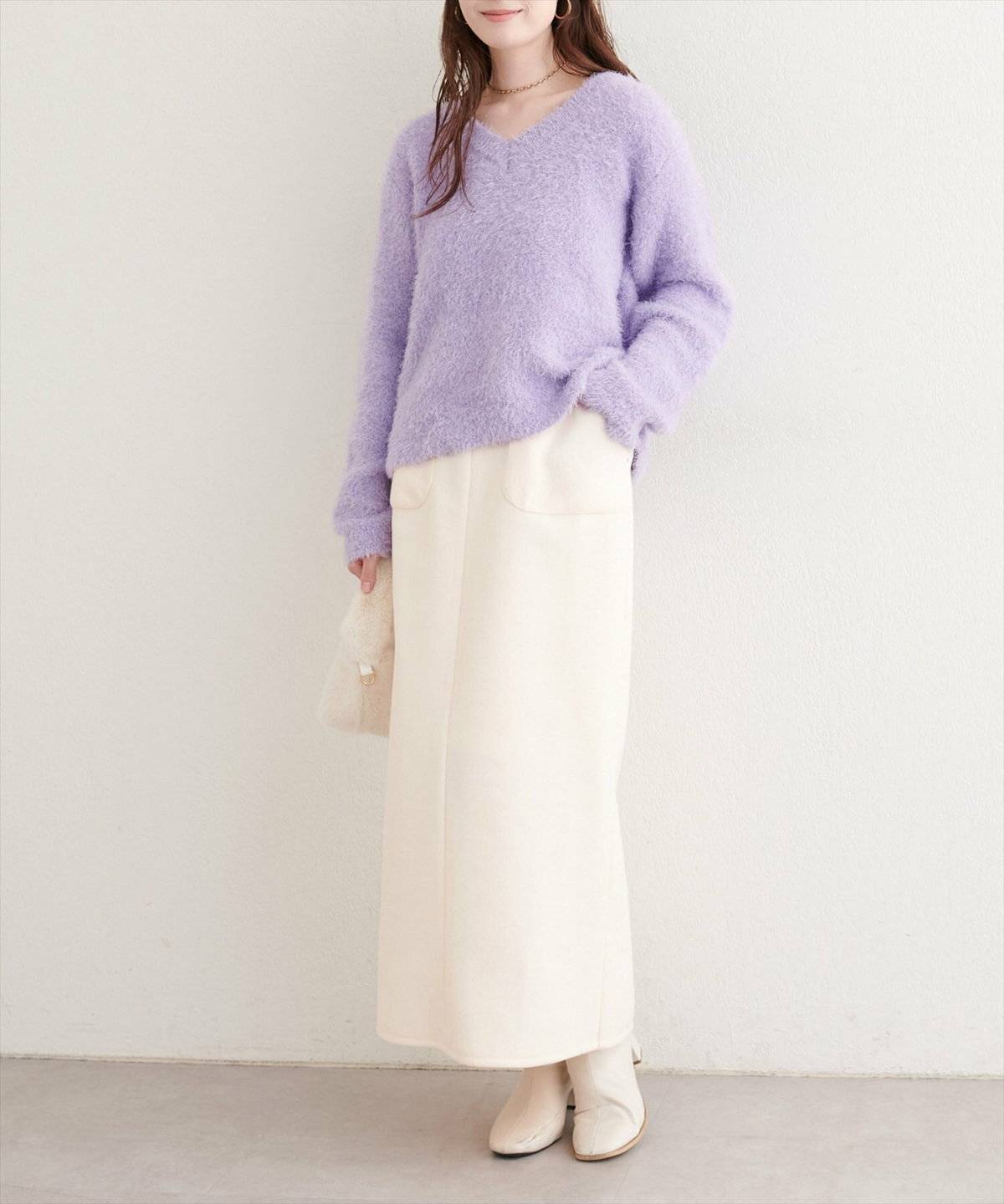 ラベンダーシャギーニット✕白スカートの女性
